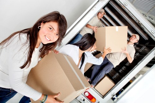 Moving team arranging boxes and furniture inside a Whetstone home